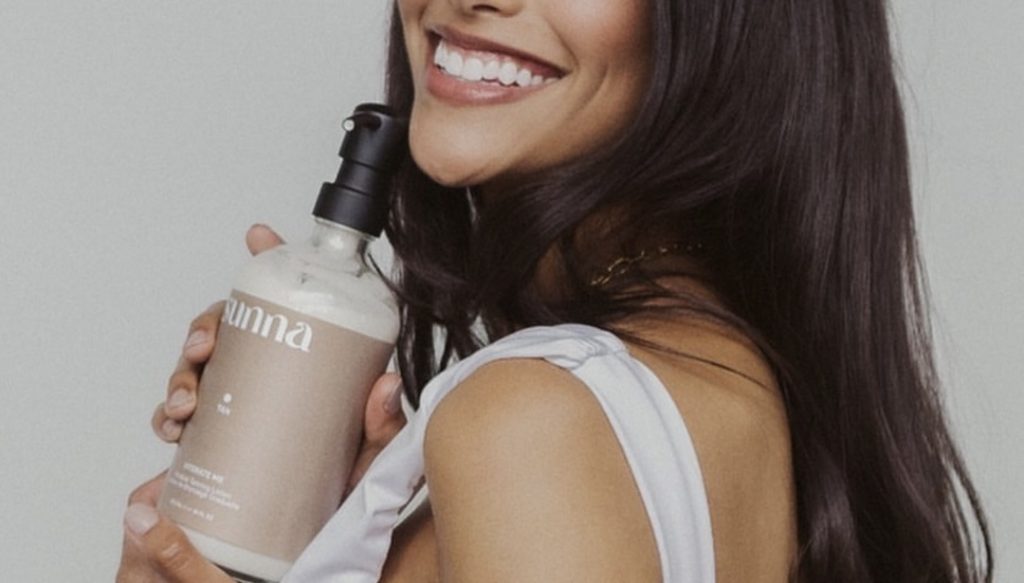 Smiling woman holding product with custom label printed by Little Rock