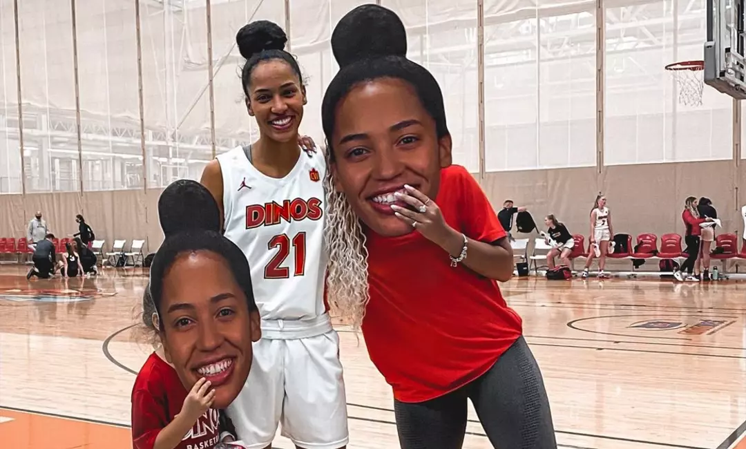 Woman basketball player with a fan holding a big head cutout of her