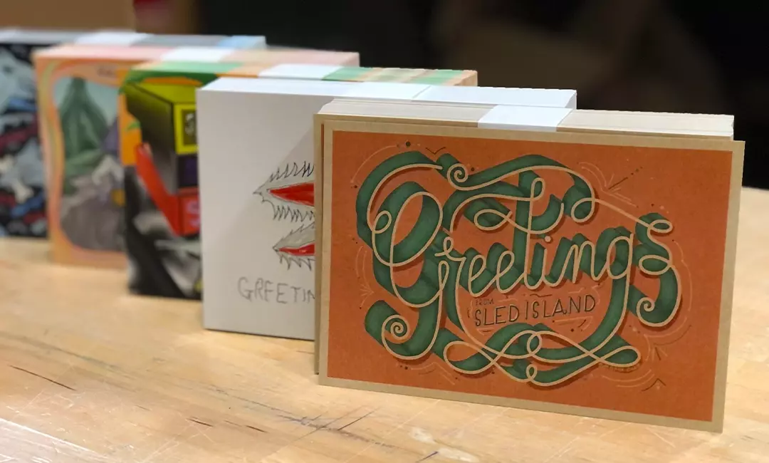 3 custom designed greeting cards sitting on wood table