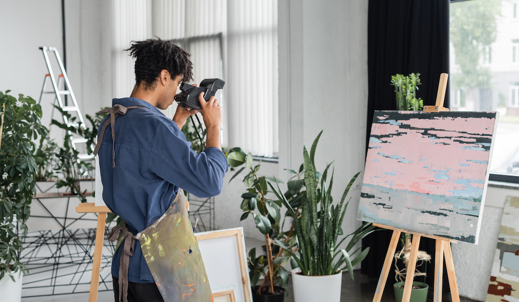 Art student photographing his painting to create art prints