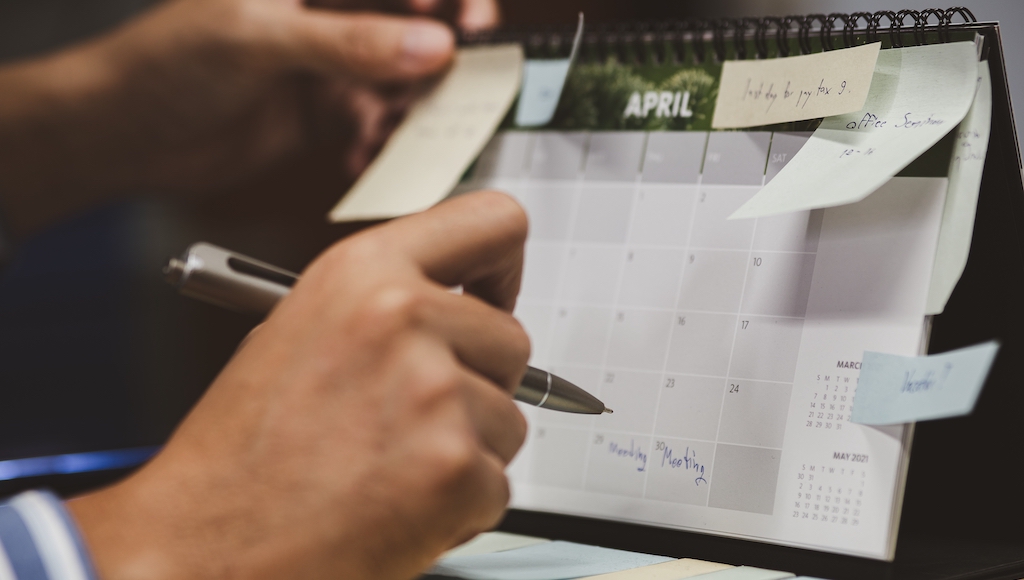 Man writing important dates on his business calendar