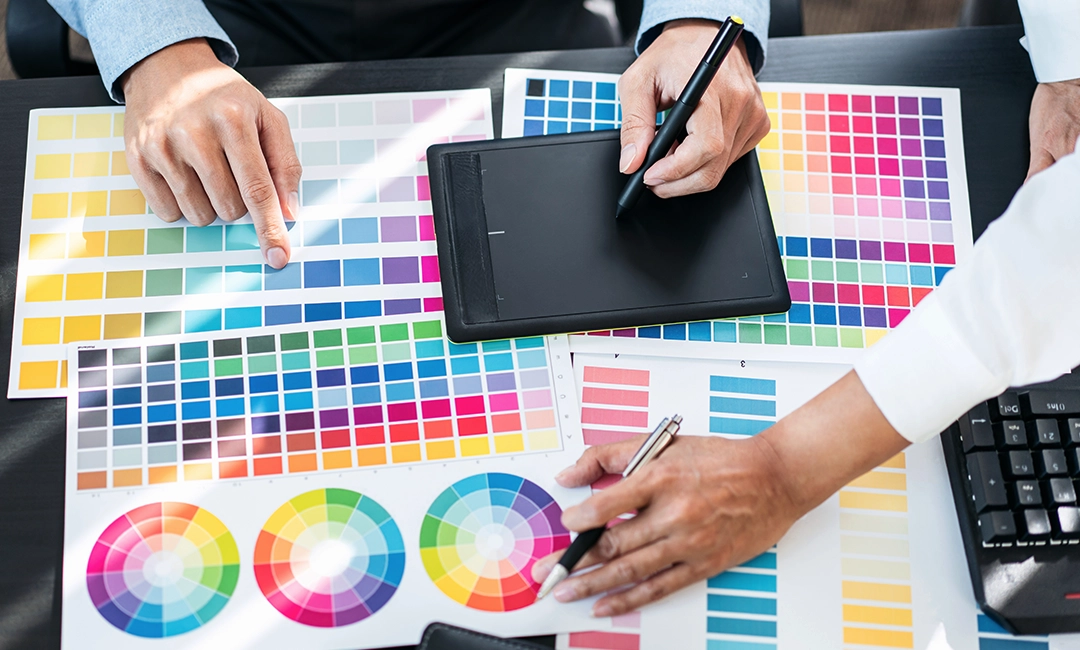 Two artist working together and looking at different colours on a palette