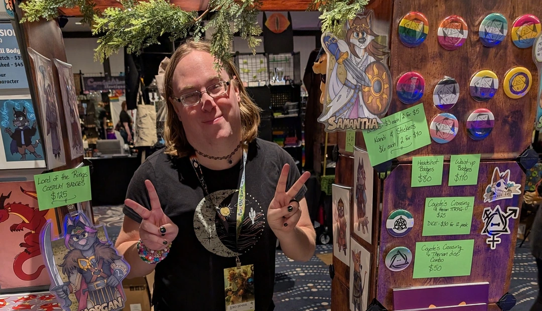 Coyote Core artist at a vendor booth displaying character prints, stickers, badges and tabletop gaming products printed at Little Rock Printing