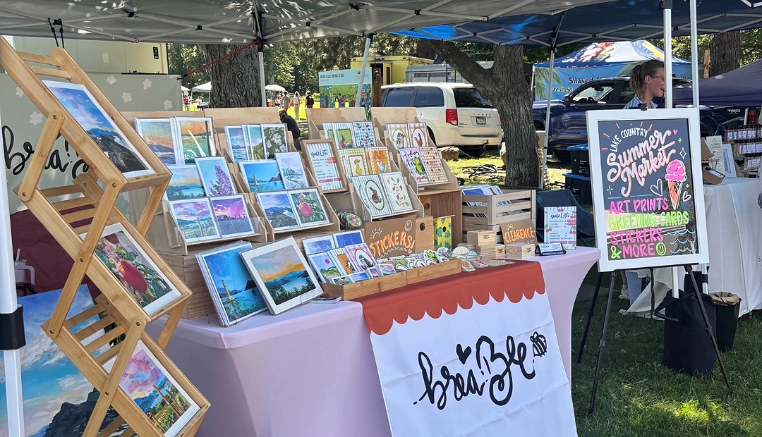 Brea Bee art prints, greeting cards and stickers displayed at an outdoor market, printed at Little Rock Printing