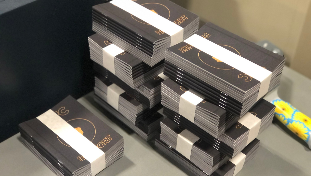 Piles of booklets printed by Little Rock Printing® put together with saddle-stitch binding