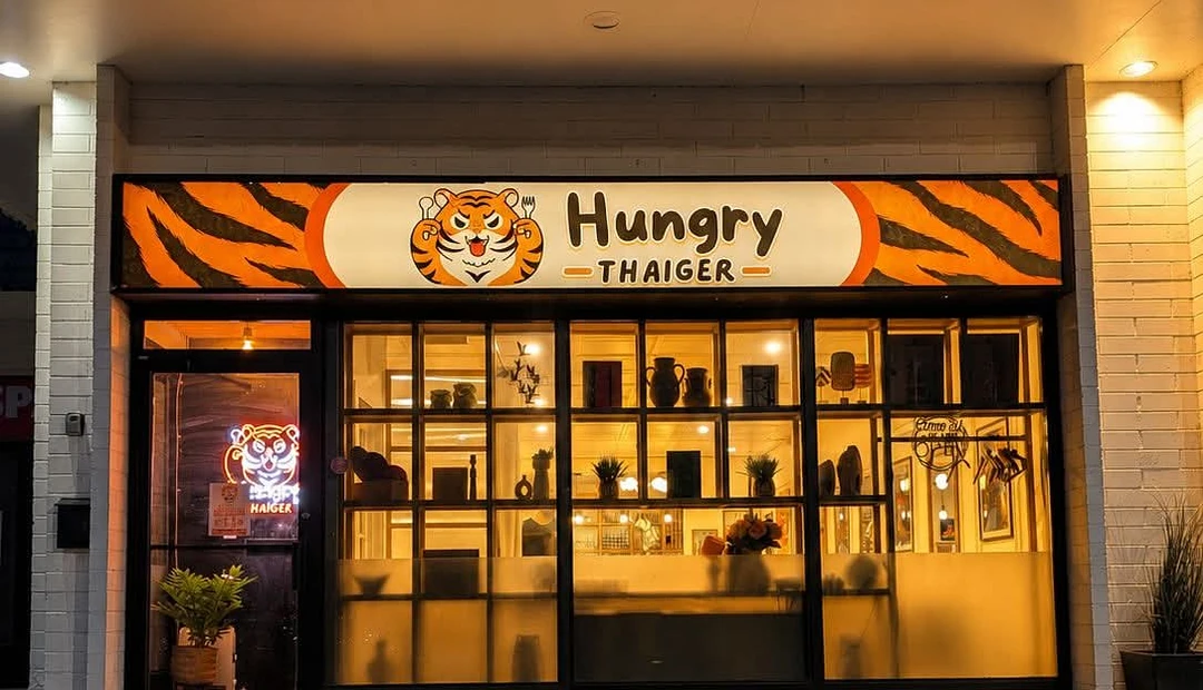 Hungry Thaiger restaurant storefront featuring illuminated custom business signage printed at Little Rock Printing.