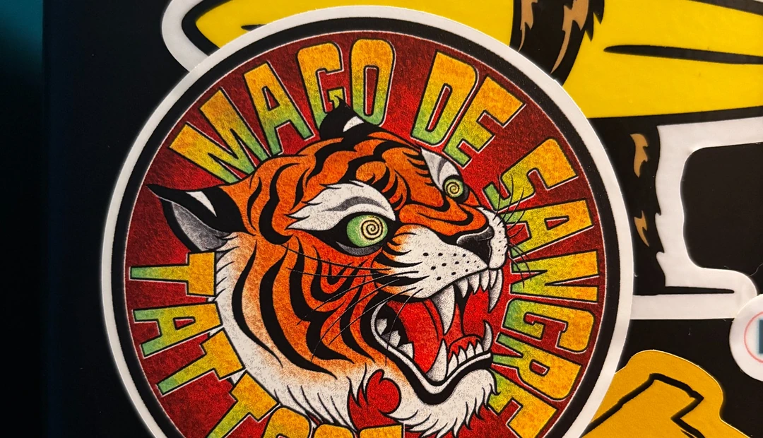 Colourful Mago de Sangre Tattoos tiger sticker displayed alongside illustrated bear and skull stickers, printed at Little Rock Printing.